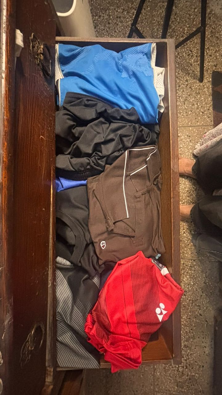 Before: a wooden drawer with sports t-shirts and trousers loosely stacked