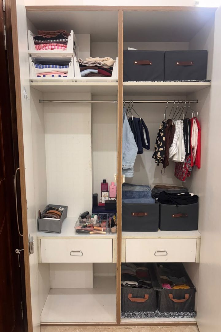 After: the same wardrobe with matching storage boxes, spaced hanging clothes and a tidy vanity shelf